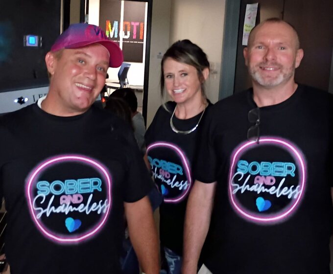 Three attendees wearing Sober and Shameless shirts at the Samba Recovery Savannah alumni event